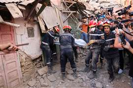 Equipes de emergência carregam um cadáver após um terremoto mortal, em Amizmiz, Marrocos, 10 de setembro de 2023. 